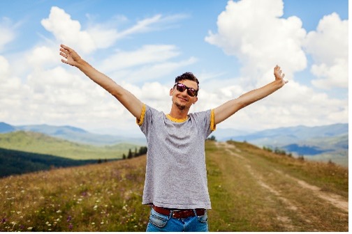 Person with their arms up in a field